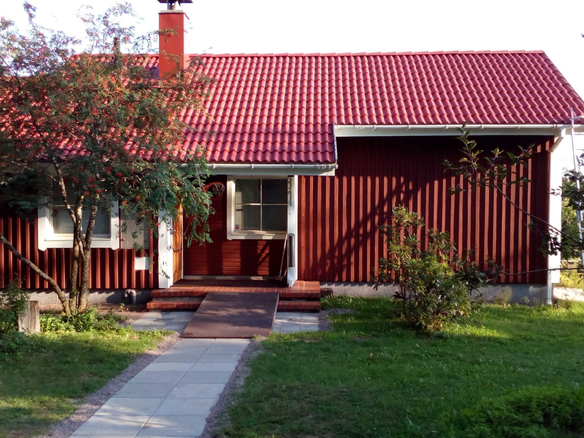 Valmis pinnoitettu tiilikatto punaisen omakotitalon harjalla